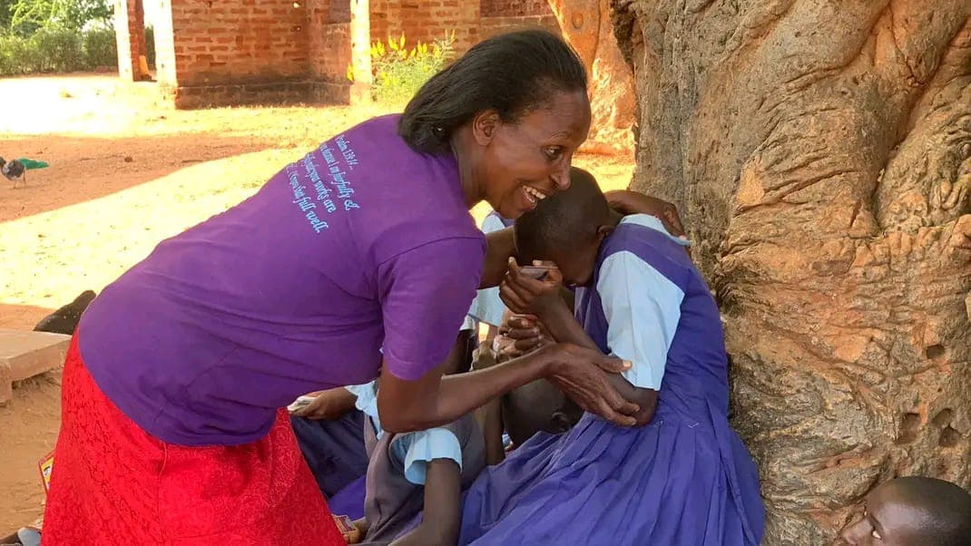 A mentor embracing a girl with warmth and care